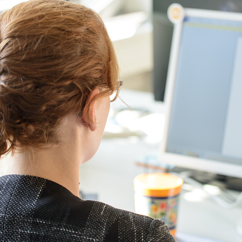 Eine Frau sitzt vor einem Computer.