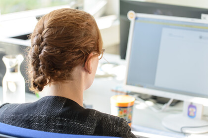 Eine Frau sitzt vor einem Computer.