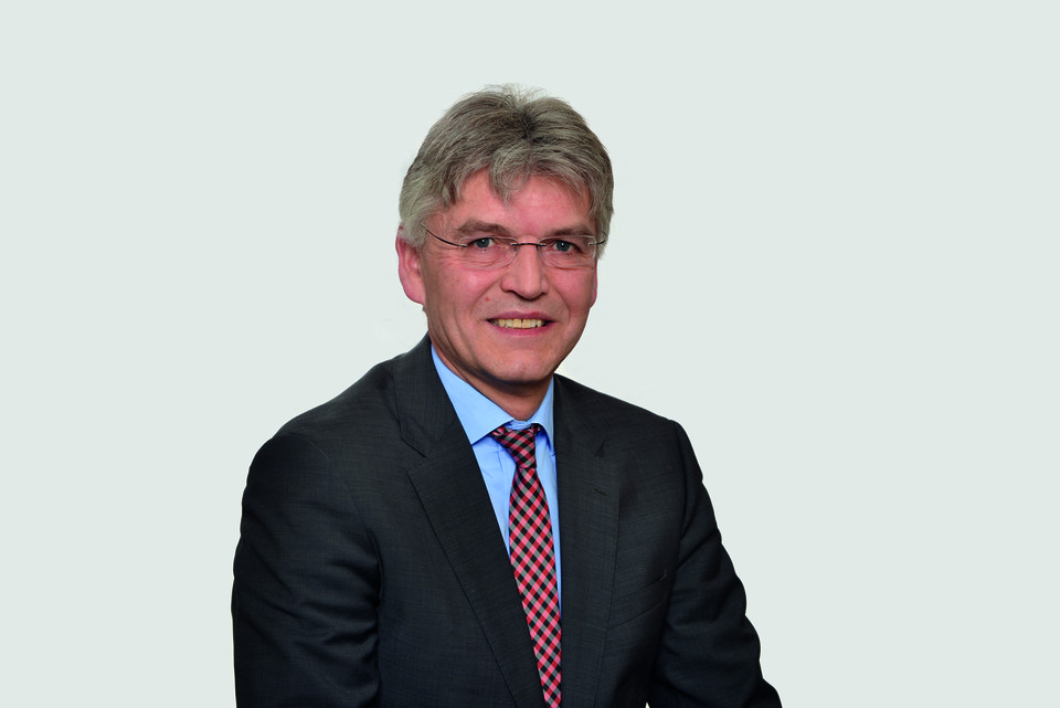 Prof. Spengel has short grey hair and wears a suit and tie.