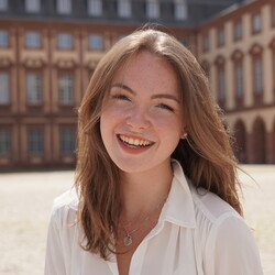 Eva Arnold has blonde hair and wears a white blouse.