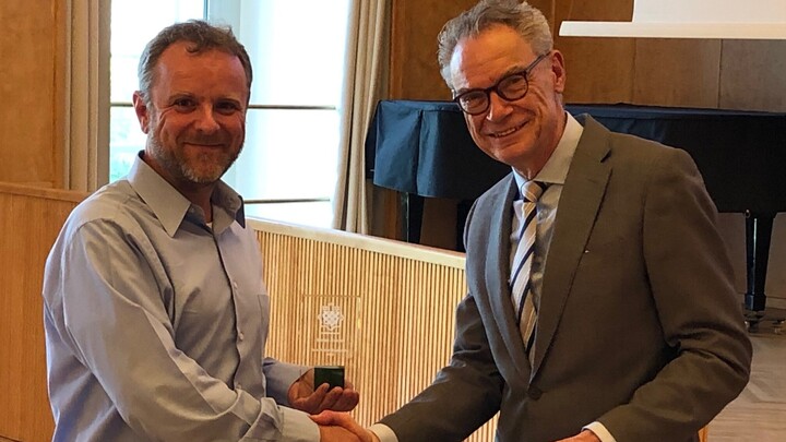 Dekan Lutz schüttelt Prof. Ruenzi die Hand und übergibt einen Preis