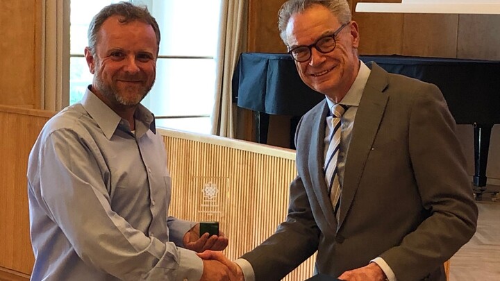 Dekan Lutz schüttelt Prof. Ruenzi die Hand und übergibt einen Preis