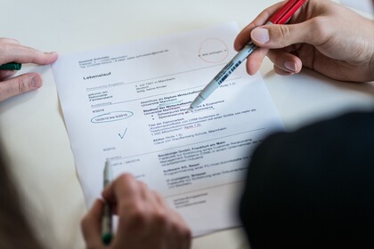 Hände mit Stiften auf Dokument