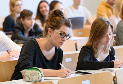 Studentinnen schreiben bei einer Vorlesung mit.