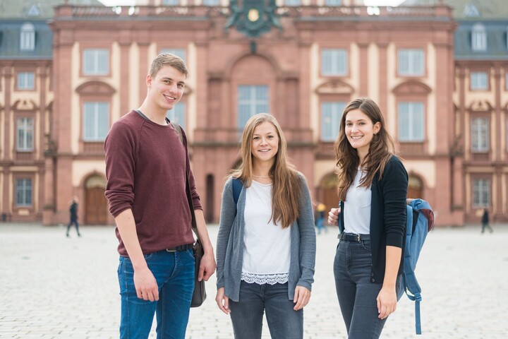 Drei Studierende vorm Schloss