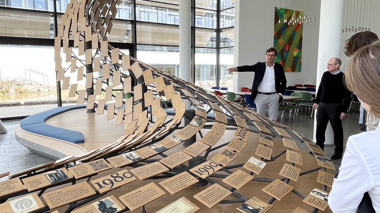 Installation aus kleinen Holzschildern und Personen, die die Schilder lesen