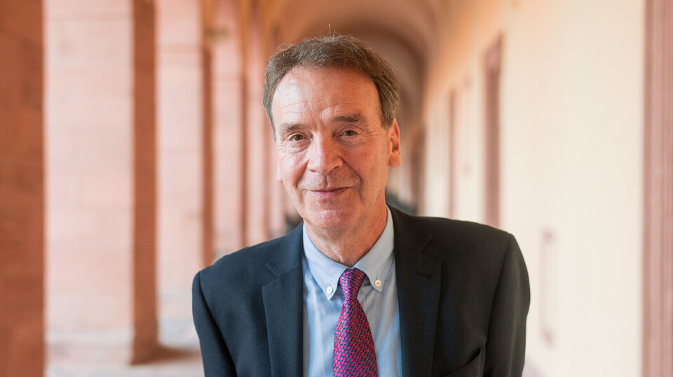 Prof. Reichelstein hat kurze Haare und trägt Anzug und Krawatte.