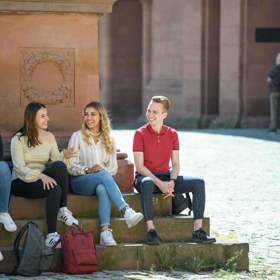 Vier Studierende vor Statue im Ehrenhof