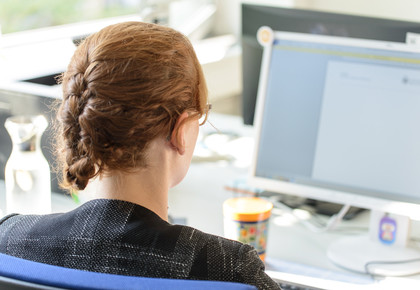 Eine Frau sitzt vor einem Computer.