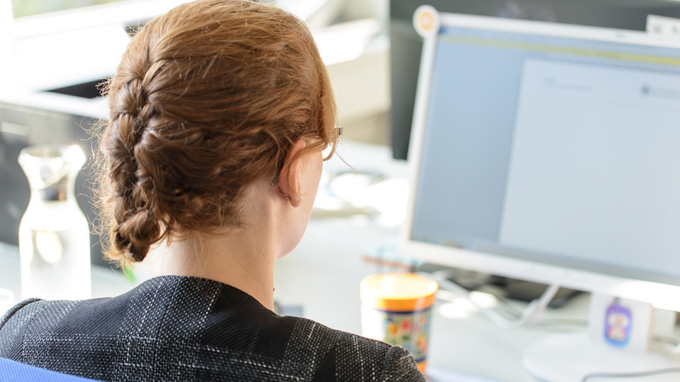 Eine Frau sitzt vor einem Computer.