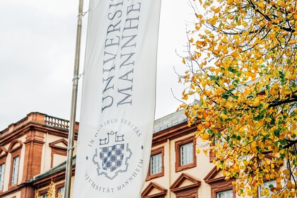 Vor dem Manheimer Schloss weht die Fahne der Universität Mannheim. 