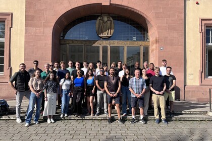 A group stands in front of the main entrance to the palace on the steps.