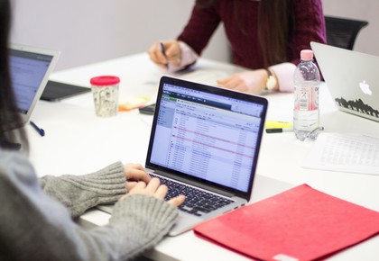 Tisch mit Lernmaterialien und Laptop auf dem ein E-Mail Postfach geöffnet ist