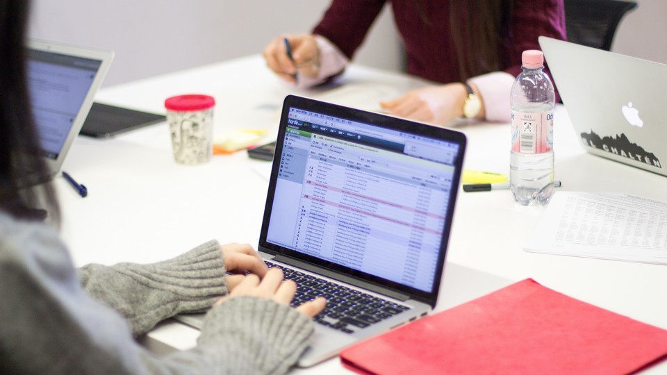 Tisch mit Lernmaterialien und Laptop auf dem ein E-Mail Postfach geöffnet ist